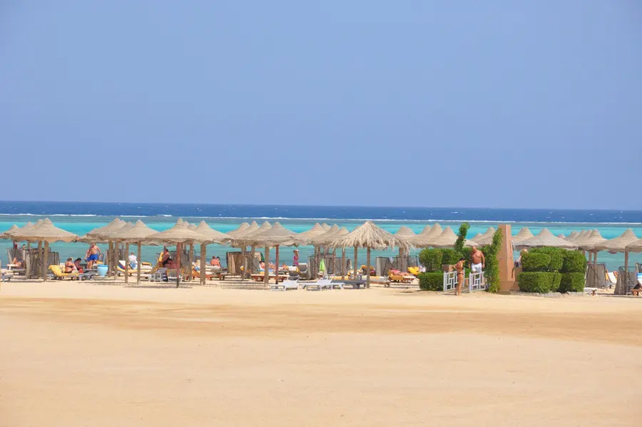 Rows of beach umbrellas on the sand by the turquoise sea